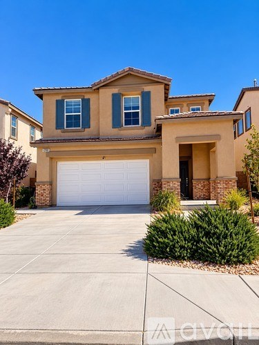 A beige house with a white garage door in front.