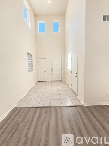 A room with wooden flooring and white walls, with a logo that reads "avaiL" on the floor.