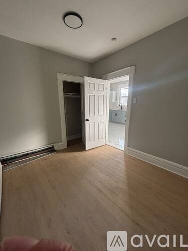 A room with a wooden floor and a white door.