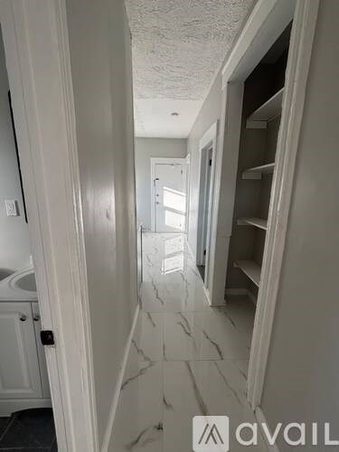 A hallway with a marble floor and white walls.