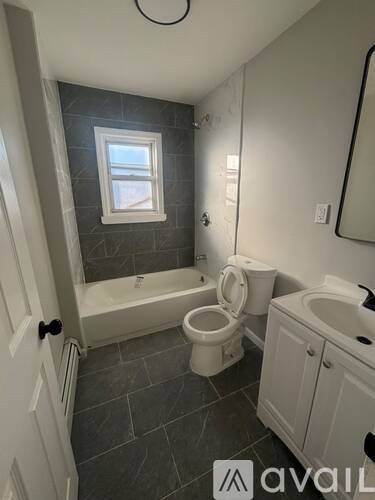 A bathroom with a toilet, tub, and sink.
