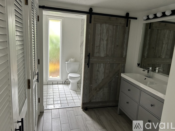 A bathroom with a toilet, sink, and mirror.