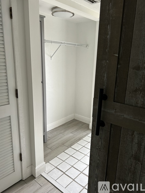 A bathroom with a walk-in shower and a wooden door.