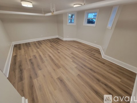 A room with wooden flooring and white walls.