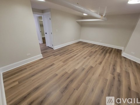 A room with wooden flooring and a white door.