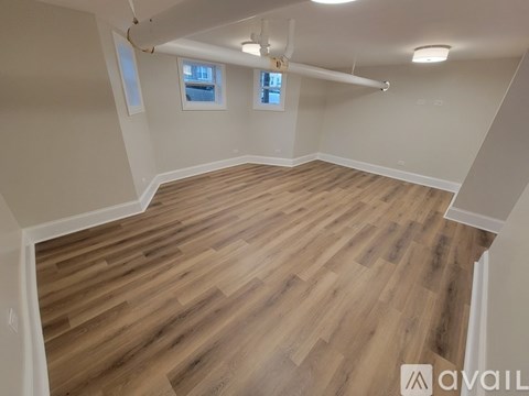 A room with wooden flooring and a window.