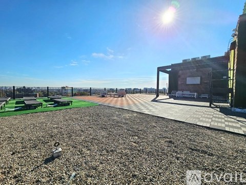 A sunny day at a gravel field with a building on the right.