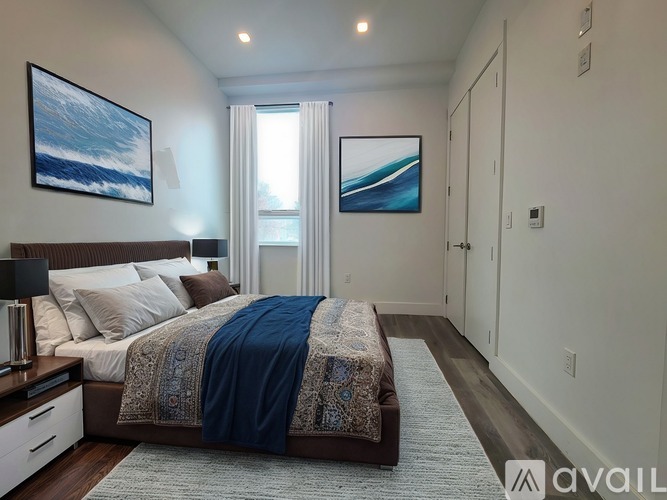 A bedroom with a bed, a nightstand, and two pictures on the wall.