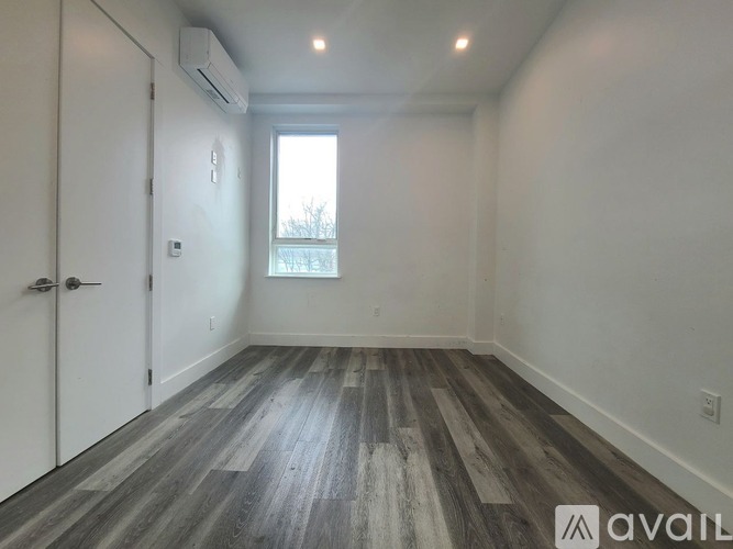 A room with a wooden floor and a window.