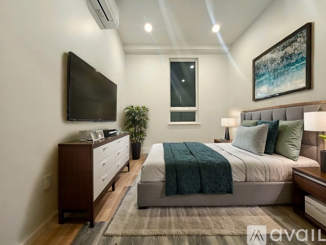 A bedroom with a bed, nightstand, and a television.
