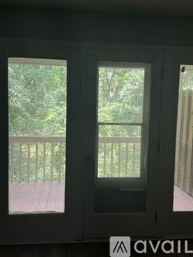 A deck with a railing and trees in the background.