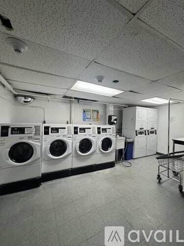 A laundromat with a row of washers and dryers.
