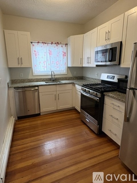 A kitchen with wooden floors and white appliances.