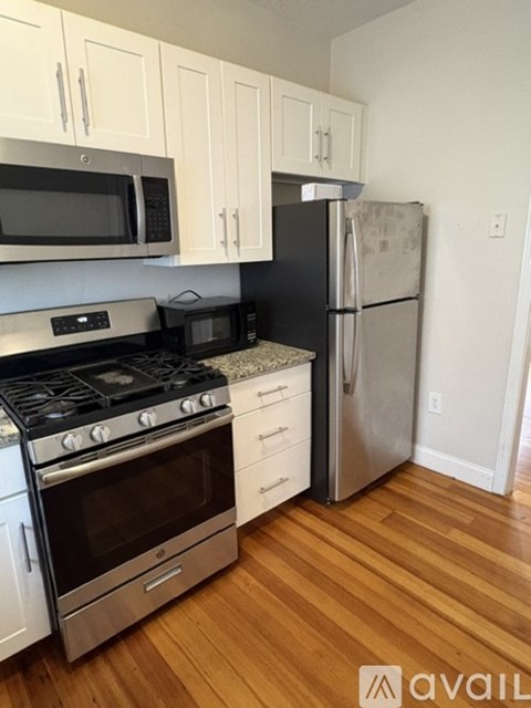 A kitchen with a stove, microwave, and refrigerator.