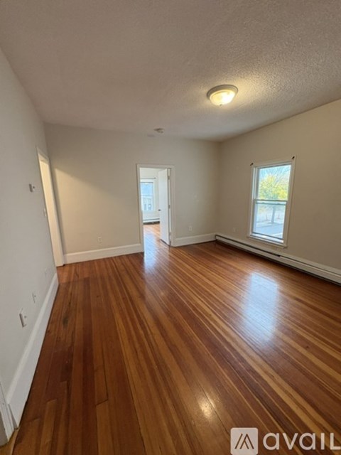 A room with wooden flooring and a window.