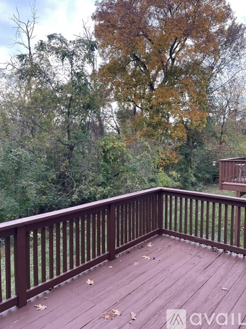 A deck with a railing and trees in the background.