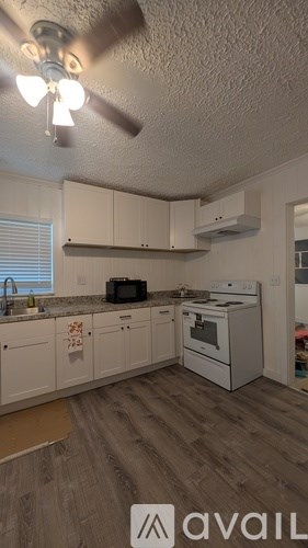 A kitchen with a fan and a stove top oven.
