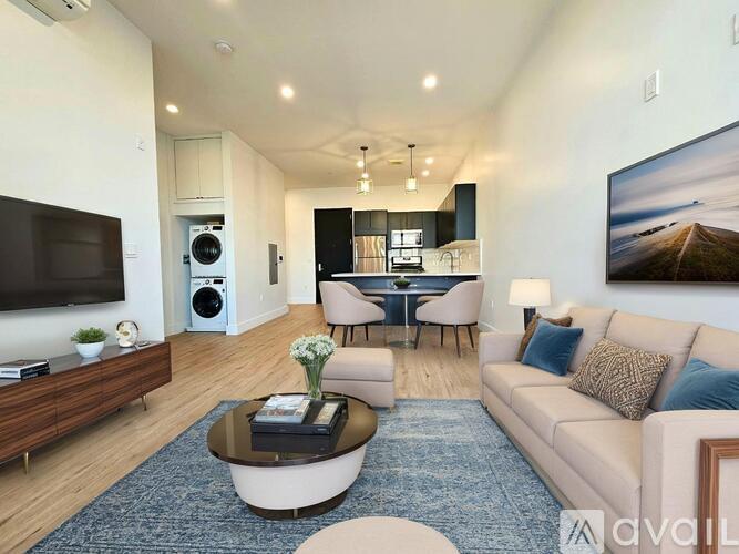 A living room with a large couch, a coffee table, and a television.