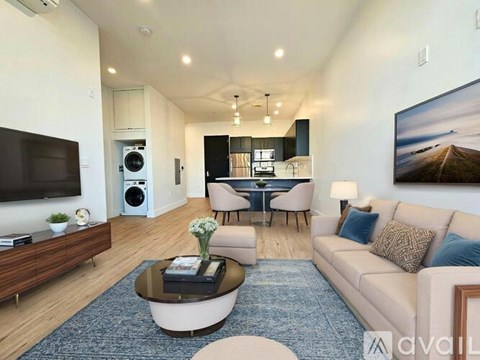 A living room with a large couch, a coffee table, and a television.