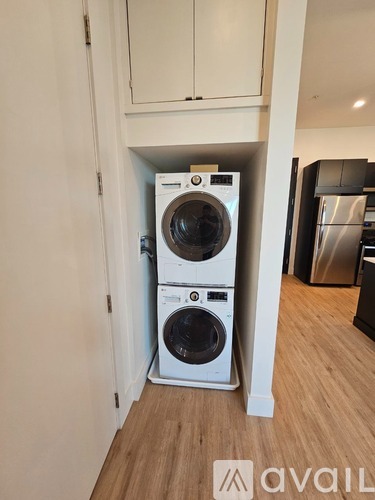 Two washing machines are stacked in a small space.