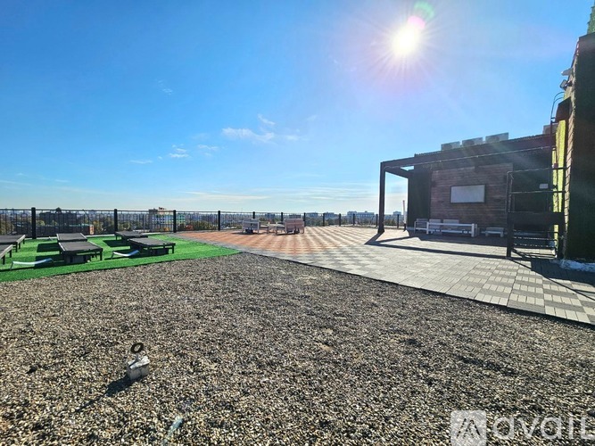 A sunny day at a gravel field with a building on the right.
