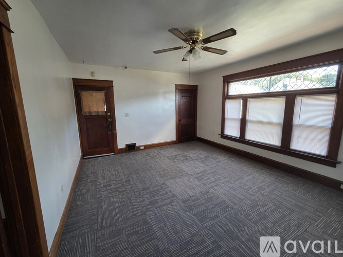 A room with a ceiling fan and carpeted floor.