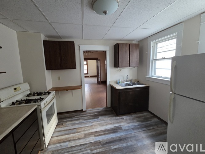 A kitchen with a stove, sink, and refrigerator.