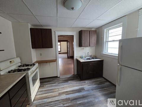 A kitchen with a stove, sink, and refrigerator.