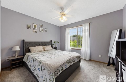 A bedroom with a large bed and a ceiling fan.