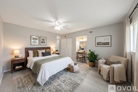 A bedroom with a large bed and a chair.