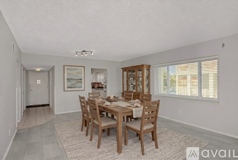 A dining room with a wooden table and chairs.