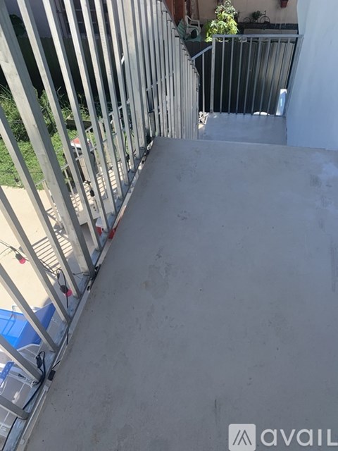 A metal fence with a gate is in front of a building.