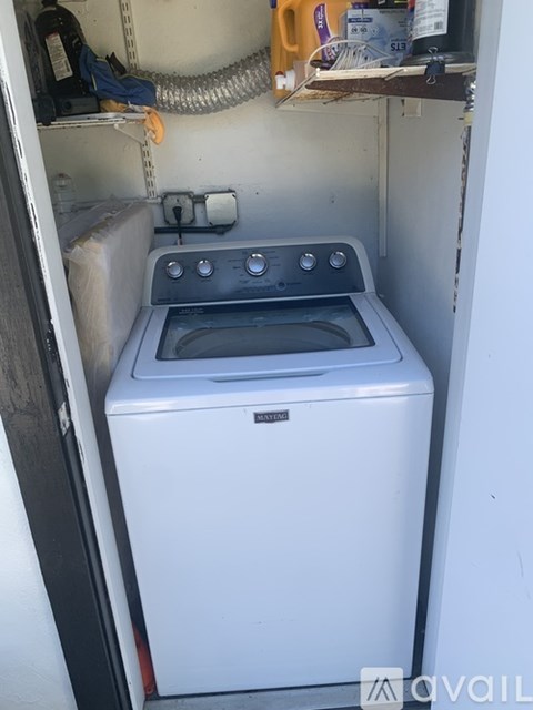 A white dishwasher is sitting in a small kitchen.
