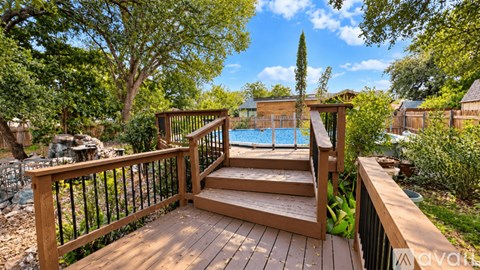 A wooden deck with a pool in the background.