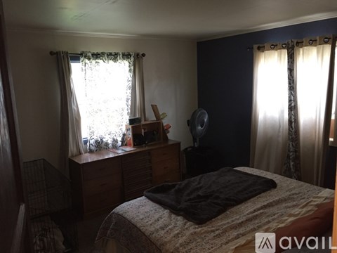 A bedroom with a bed, desk, and chair.