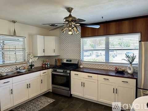A kitchen with white cabinets and a black and white checkered backsplash.