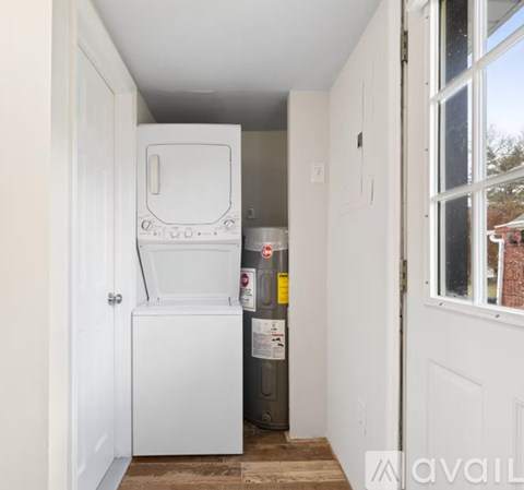 A small white fridge and freezer in a narrow hallway.