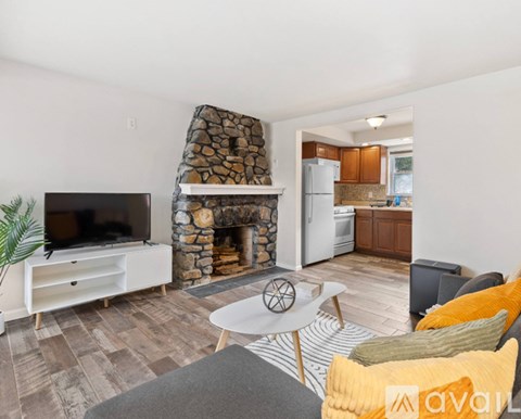 A living room with a stone fireplace and a television.