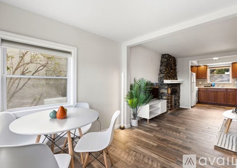 A dining room with a white table and chairs.
