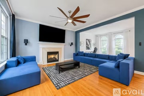 A living room with blue furniture and a fireplace.