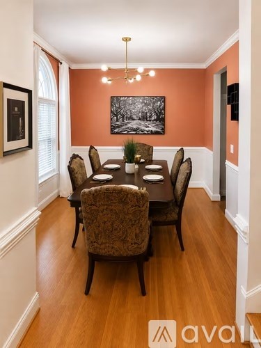A dining room with a wooden table and chairs.