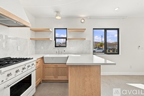 A modern kitchen with a white stove top oven and a white counter top.