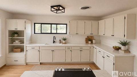 A kitchen with white cabinets and a black stove top.