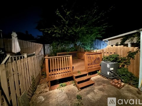 A backyard with a deck and a hot tub.