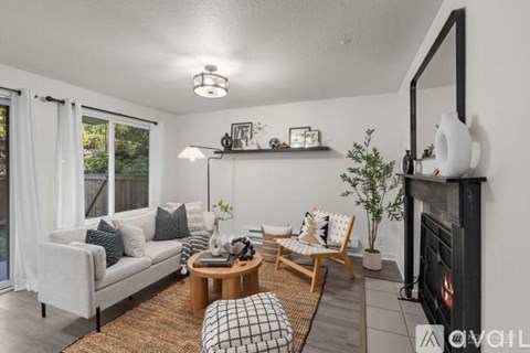 A living room with a grey couch, a coffee table, and a fireplace.
