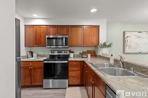 A kitchen with wooden cabinets and stainless steel appliances.