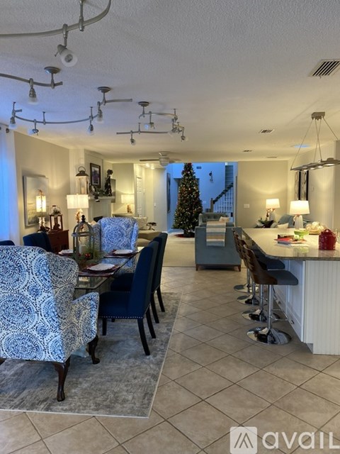 A dining room with a Christmas tree in the background.
