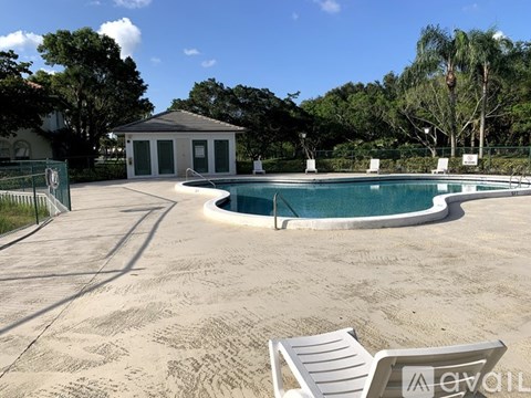 A sandy backyard with a pool and a small building.