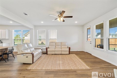 A living room with a white sofa and a ceiling fan.