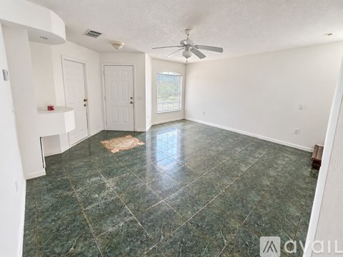 A room with a green marble floor and a ceiling fan.